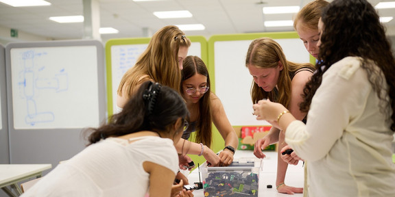 Schülerinnen beim Workshop-Tag an der Fakultät Maschinenbau. Eine Gruppe von Schülerinnen beugt sich über eine Kiste mit Legosteinen