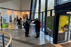 Foyer mit Stehtischen und Besucherinnen und Besuchern