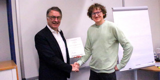 The photo shows Prof. Schulze Darup (Dean) presenting the certificate to Prof. Clausen (Head of the Institute itl).