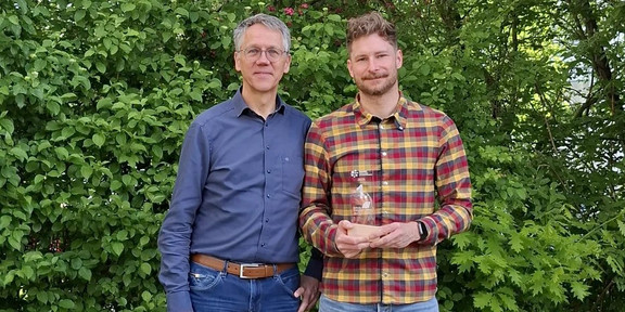 Die Fotoaufnahme zeigt Prof Brümmer des Fachgebiets Fluidtechnik zusammen mit dem Preisträger Felix Nal