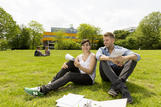 Two students sitting on a lawn