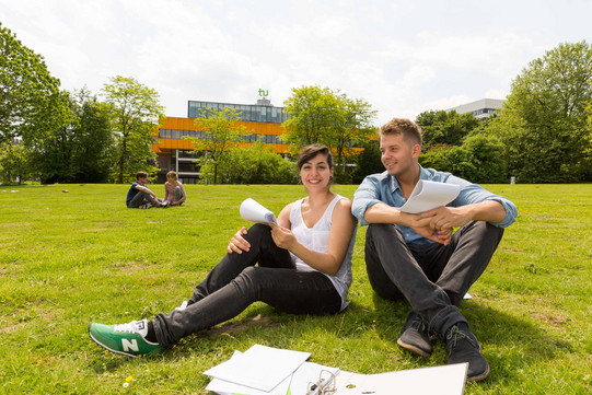 Two students sitting on a lawn