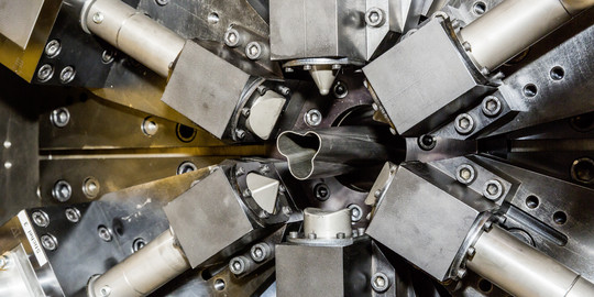 Ein Metallrohr wird in einer Maschine geformt.
