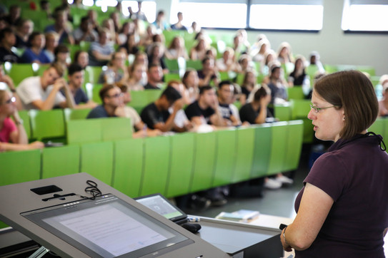 Dozierende sitzt vor Studierenden im Hörsaal im Seminargebäude. 