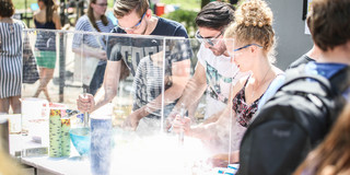 Studierende am Trockeneisstand Studierende mit Schutzbrillen am Trockeneisstand